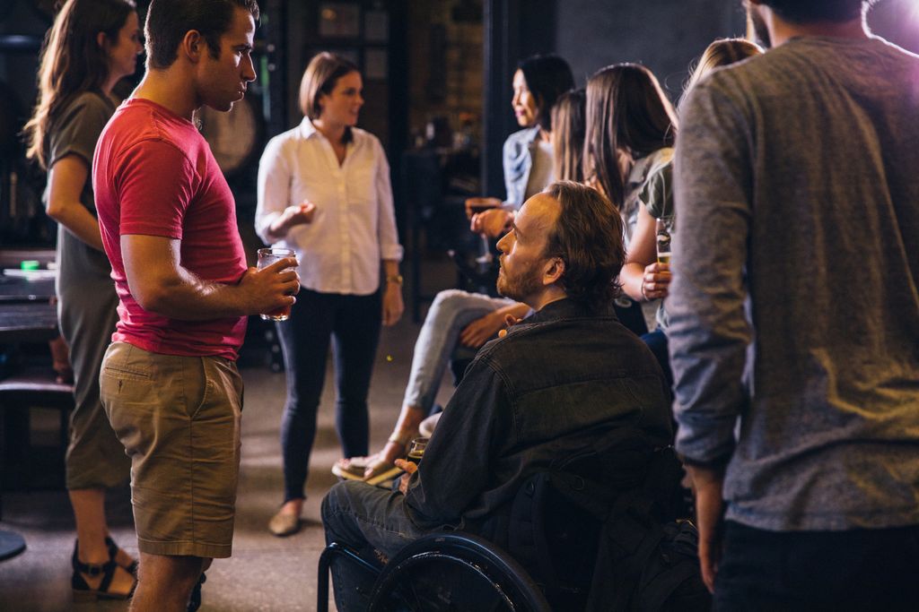 A diverse group socializing in a modern bar setting, promoting inclusion.