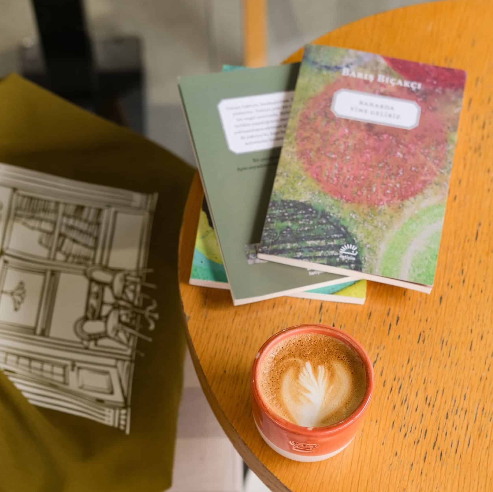 Warm coffee shop setting with books and latte art creating a relaxing atmosphere.